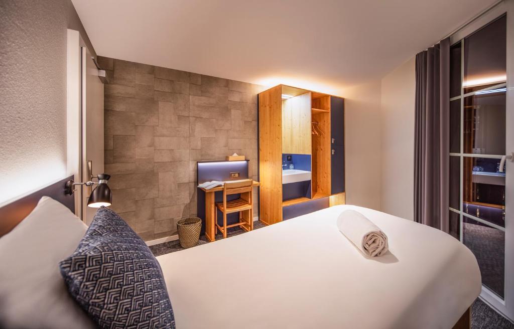 a hotel room with a bed and a television at Villars Lodge in Villars-sur-Ollon