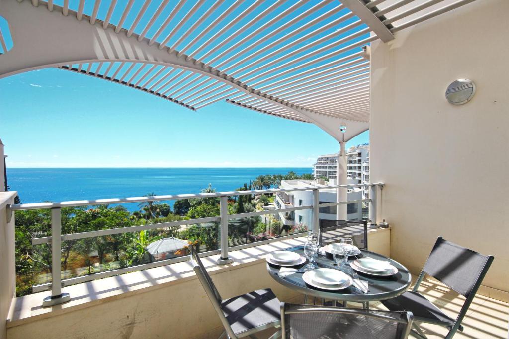フンシャルにあるOceanside Terrace Apartment by HR Madeiraの海を望むバルコニー(テーブル、椅子付)