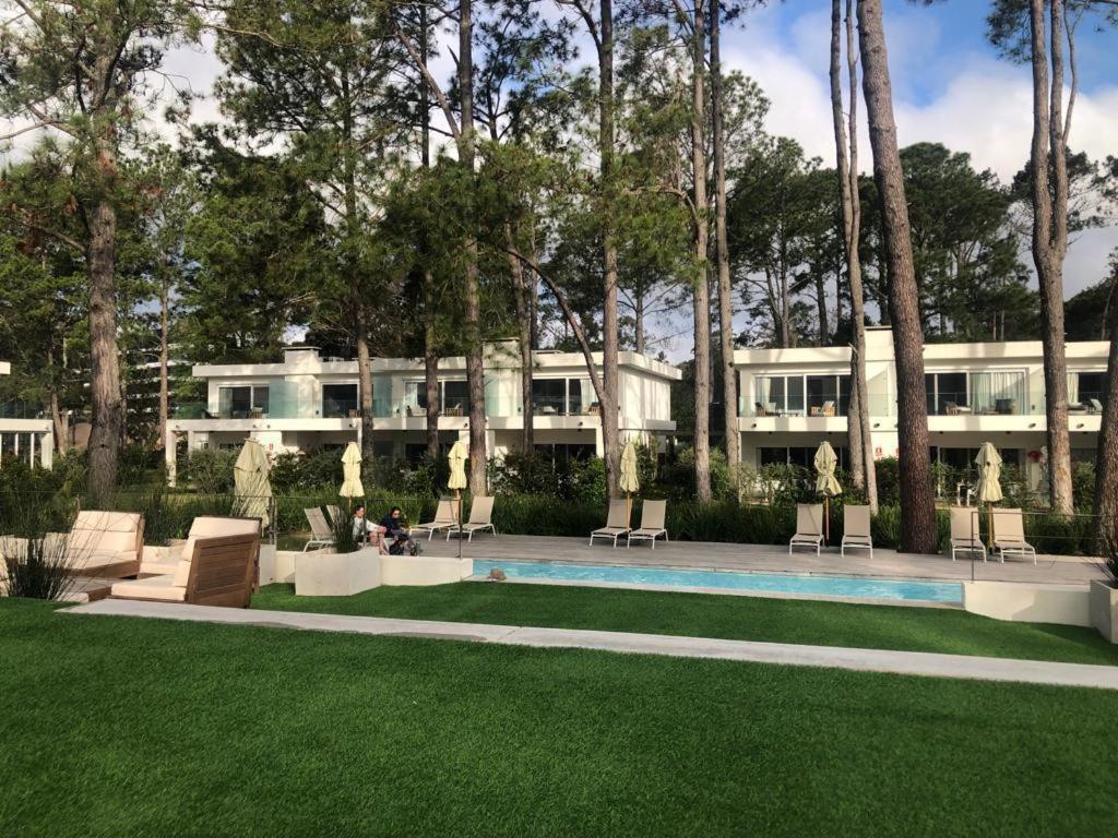 un gran edificio con una piscina frente a un patio en Garden View 2 Dormitorios con Jardín y Parrillero hasta 7 personas en Punta del Este