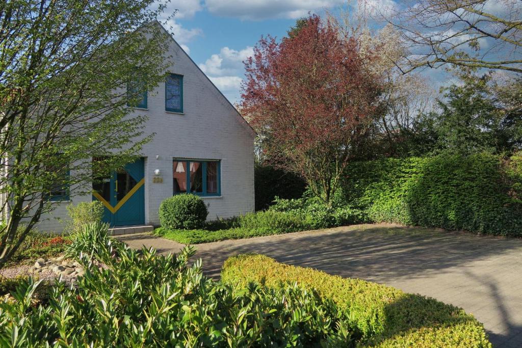 a white house with a blue door at FeWo Grafschaft in Nordhorn