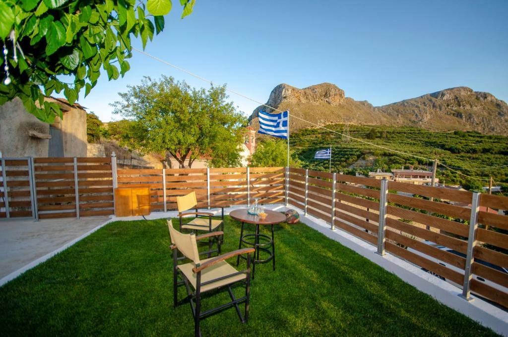 eine Terrasse mit einem Tisch und Stühlen auf dem Rasen in der Unterkunft Trouli Rokka House in Kissamos