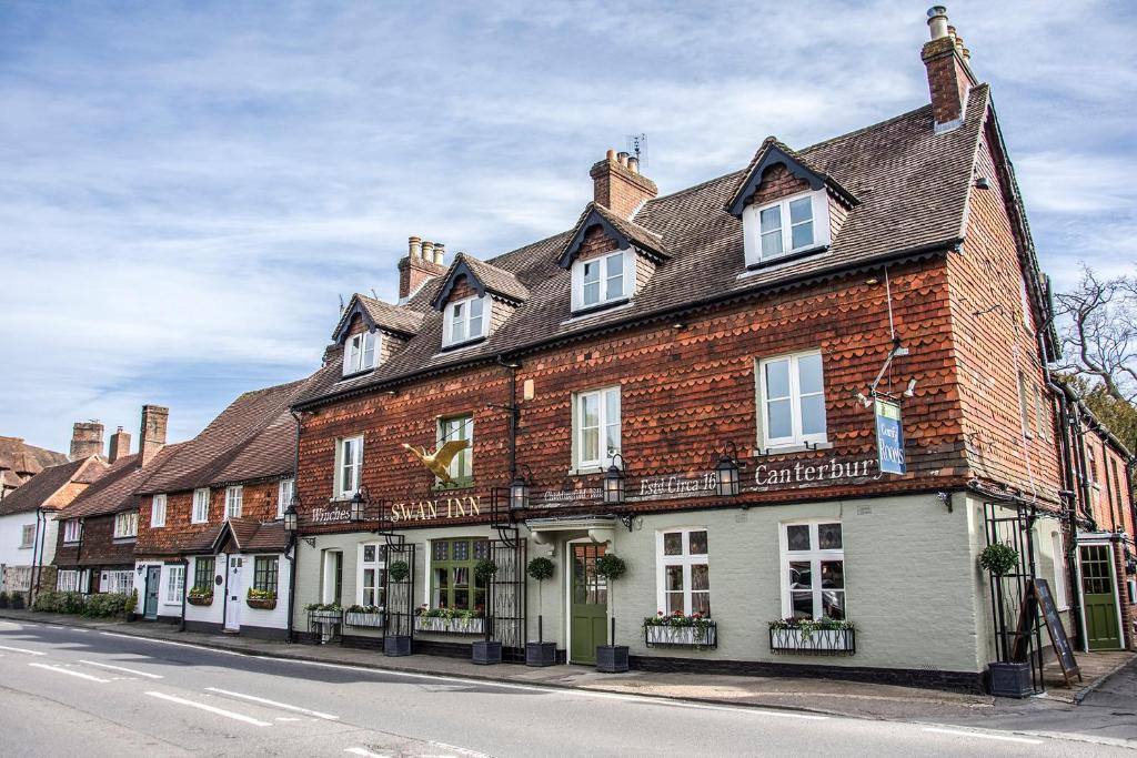 a large brick building on the side of a street at The Swan Inn in Chiddingfold