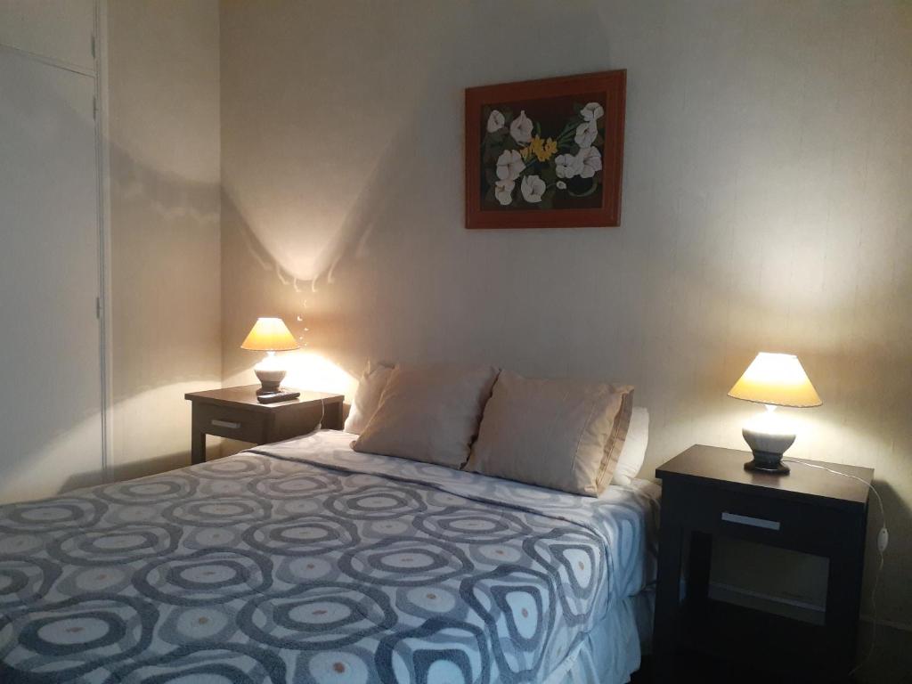 sypialnia z łóżkiem i 2 lampkami na stołach w obiekcie Departamento Mar del plata, solo grupo familiar w mieście Mar del Plata