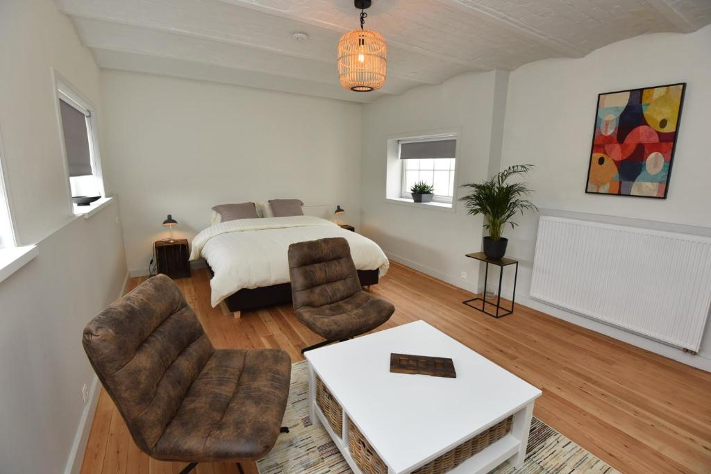 a bedroom with a bed and a table and chairs at B&B 't Burreken in Schorisse