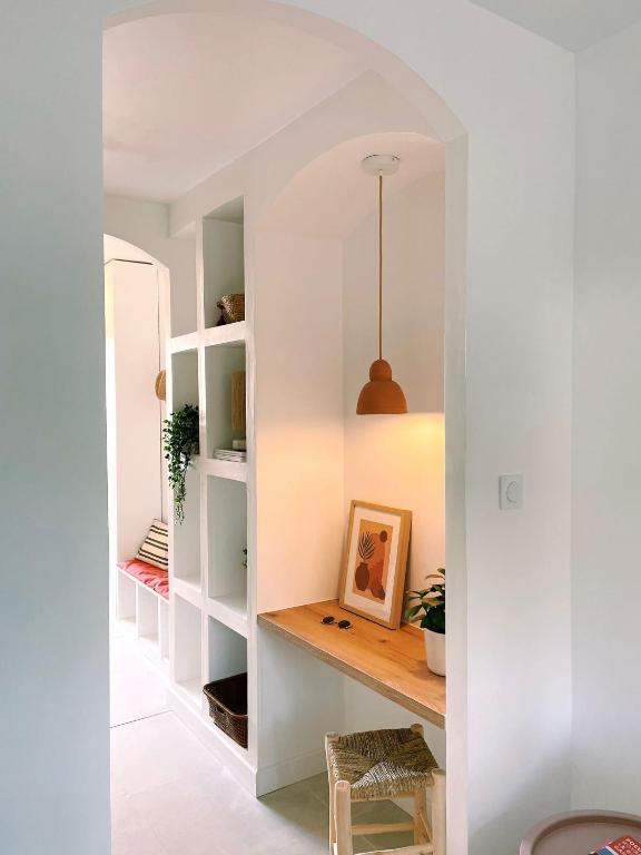 Cette chambre dispose de murs blancs et d'une étagère avec une photo. dans l'établissement Studio d'architecte à 150 m de la plage, à Royan