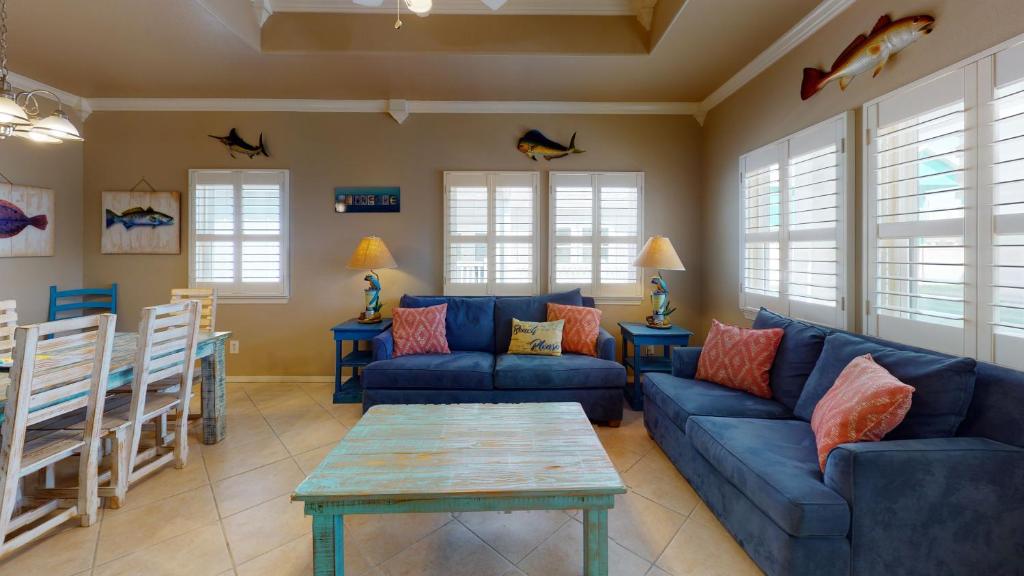 a living room with blue couches and a table at SFH201 Newly Renovated Ground Floor Townhome, Shared Pool, Near Beach in Port Aransas