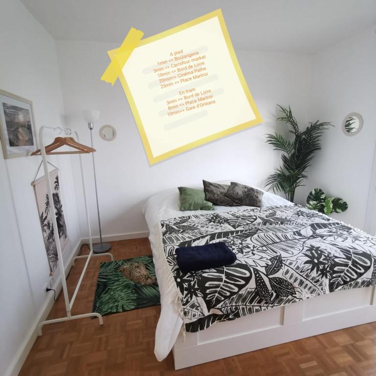 - une chambre avec un lit doté d'une couette et d'oreillers dans l'établissement Chambre Jungle - Tout confort Saint Marceau, à Orléans