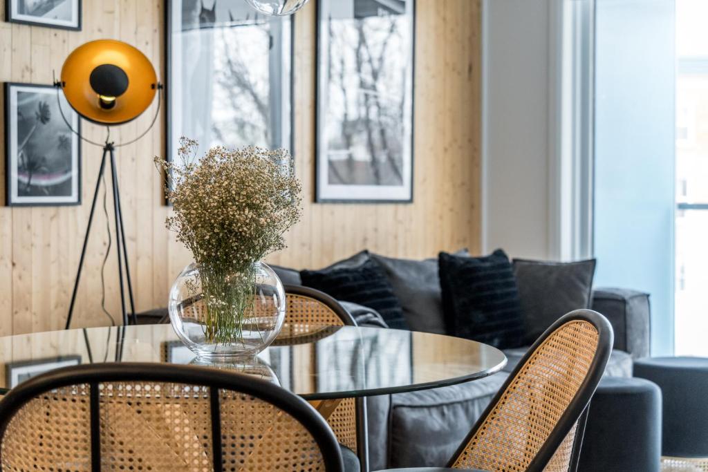 Hotel INITIAL -CLASSE S- Centre-ville de Québec +stationnement, a dining room with a glass table and chairs at INITIAL -CLASSE S- Centre-ville de Québec +stationnement in Quebec City