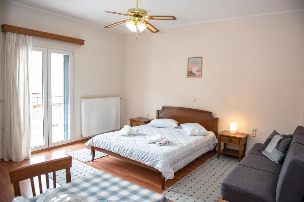 une chambre avec un lit et un canapé dans l'établissement Ξένη resort, à Karpenísi