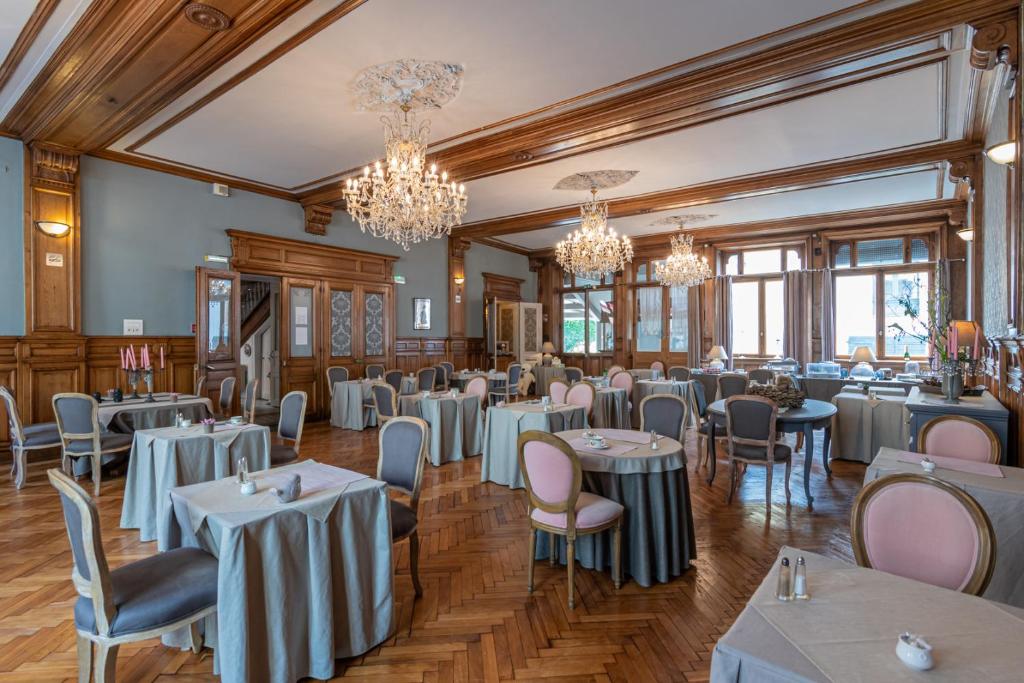 a dining room filled with tables and chairs at The Originals City, Hôtel de la Balance, Montbéliard in Montbéliard