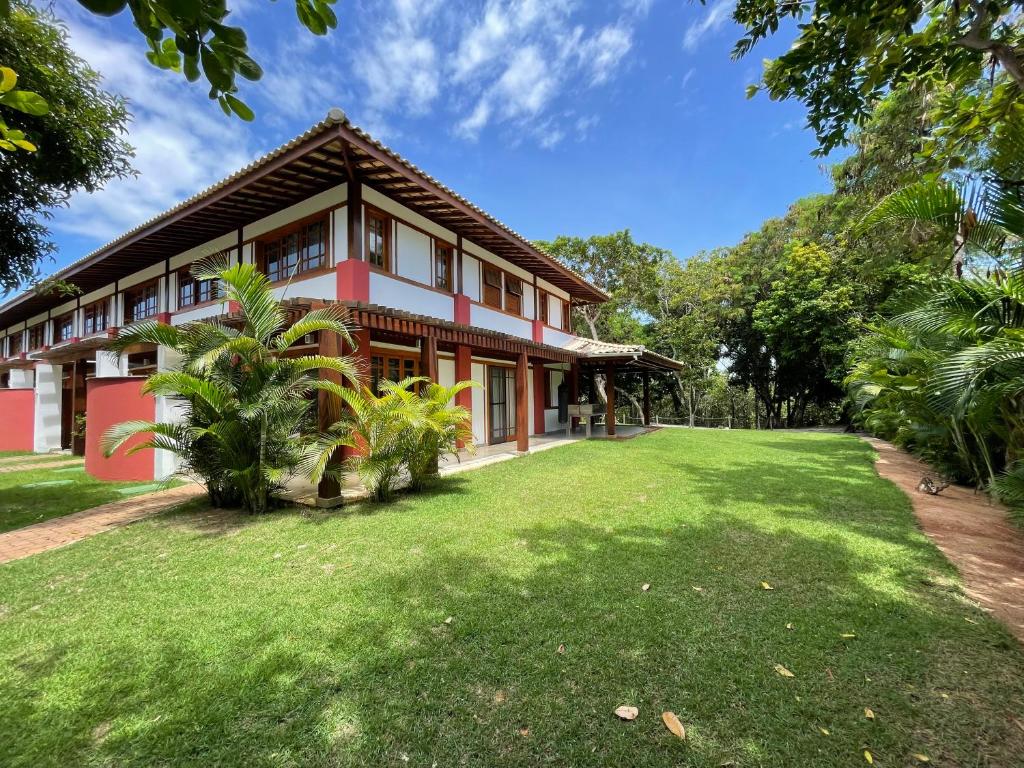 uma casa com um grande quintal em frente em Duplex aconchegante Cond Reserva Praia do Forte em Mata de São João