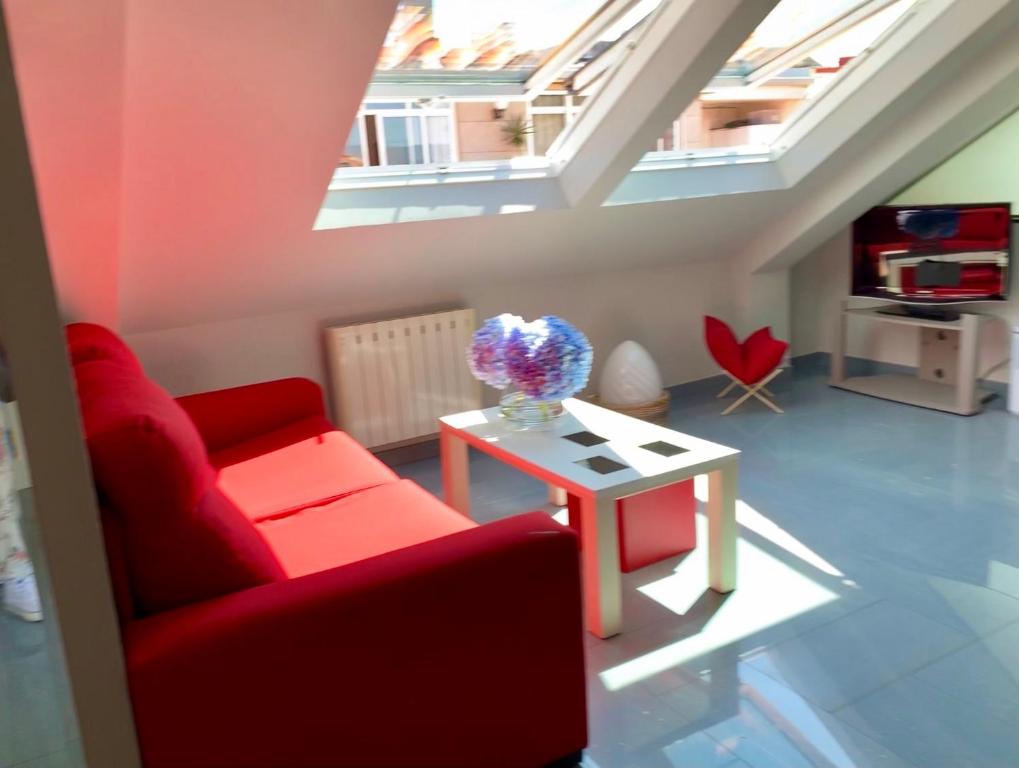 a living room with a red couch and a table at Luminoso y centrico apartamento en Plaza de España posición estratégica in Pontevedra