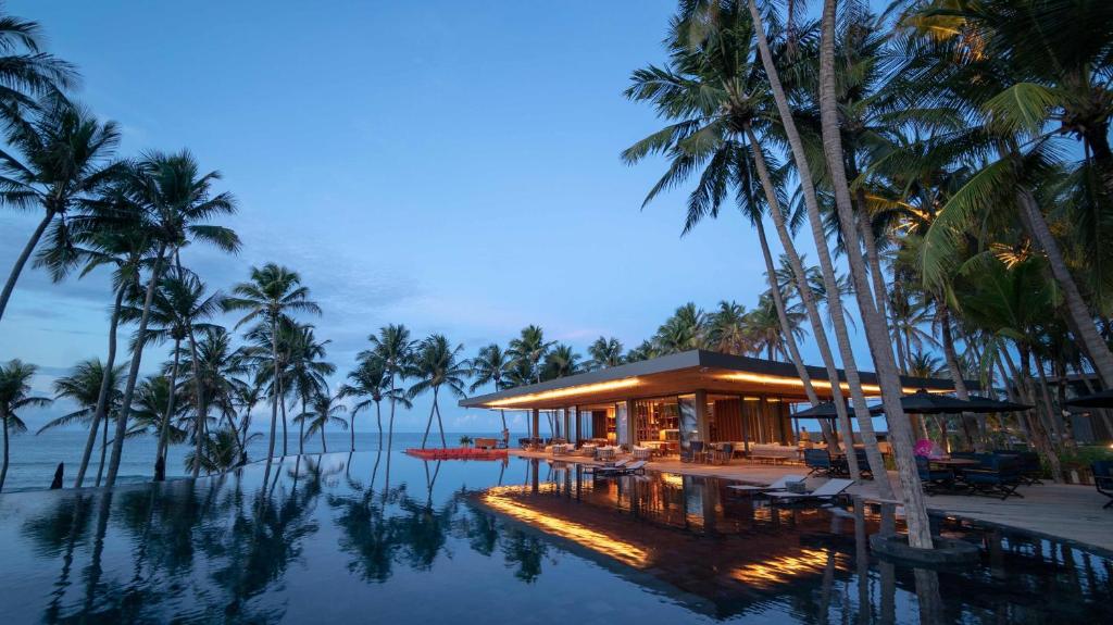 un complexe avec des palmiers et une piscine dans l'établissement Carmel Taíba Exclusive Resort, à Taíba