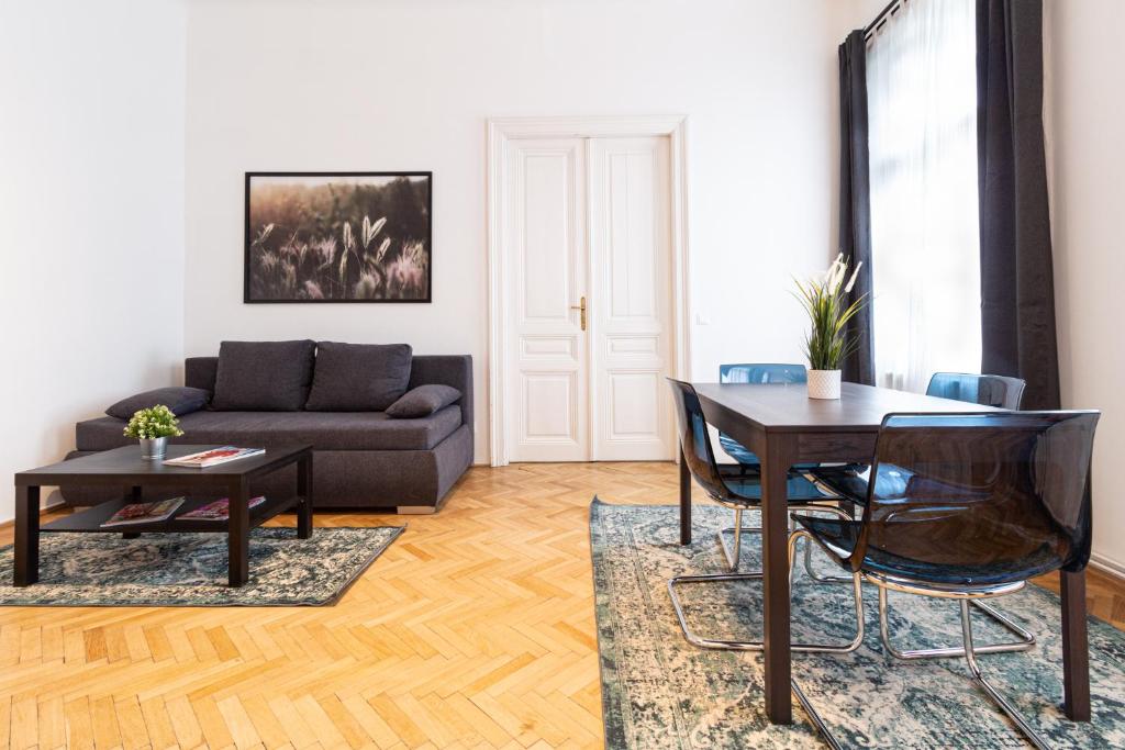 een woonkamer met een tafel en een bank bij Apartment Mariahilfer Strasse in Wenen