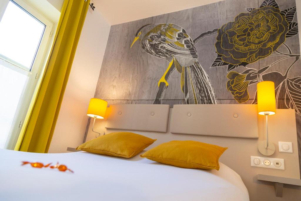 a bedroom with a bed with a bird on the wall at Hotel Victoria in Strasbourg