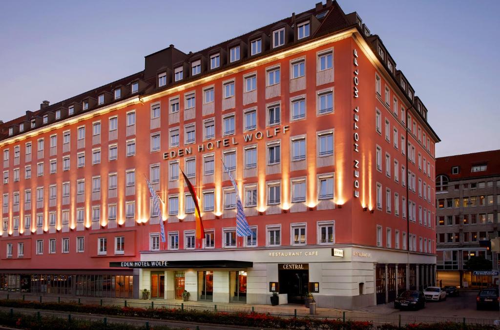 a large red building with an american hotel at Eden Hotel Wolff in Munich
