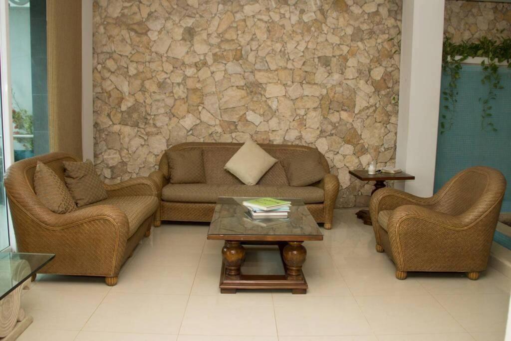 托盧的住宿－Casa de vacaciones en Tolú，带沙发和石墙的客厅