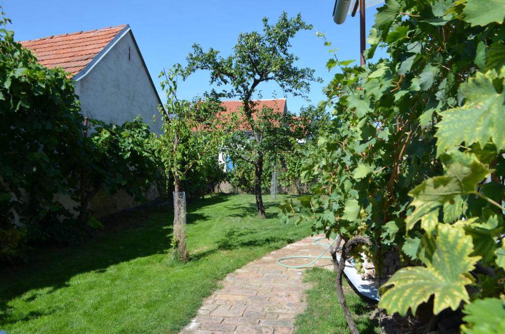 un jardin avec des arbres et un chemin en briques dans l'établissement Rodinný dům Mikulov, à Mikulov