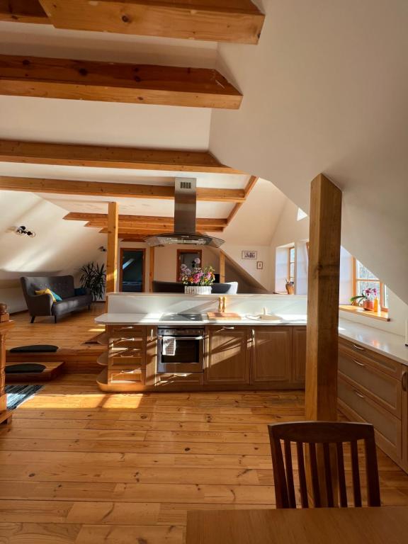 una grande cucina con pavimenti in legno e soffitti in legno di Rumbas a Kuldīga