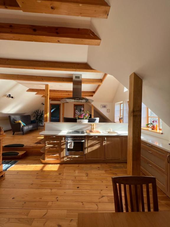a large kitchen with wooden floors and wooden ceilings at Rumbas in Kuldīga