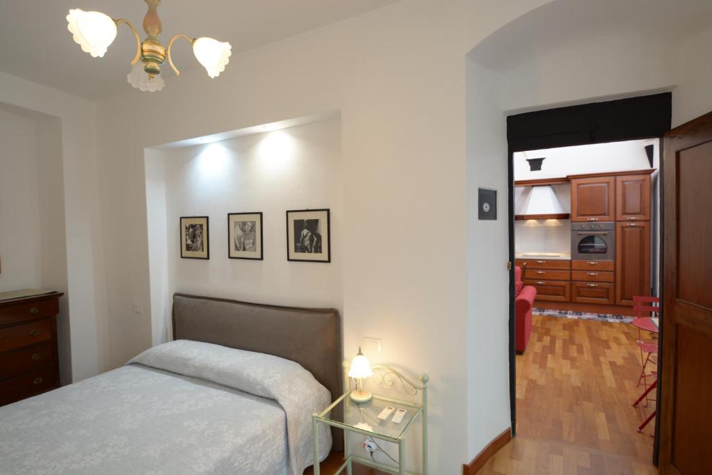 ein Schlafzimmer mit einem Bett und einem Tisch sowie eine Küche in der Unterkunft Soana Apartment in Genua