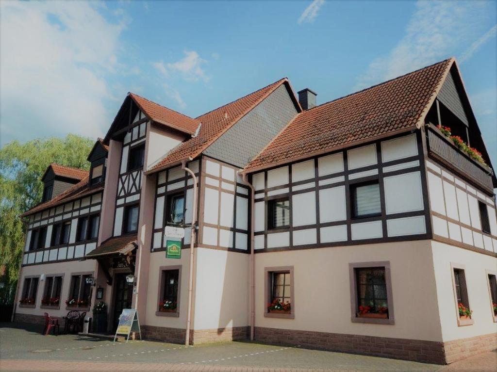 um grande edifício branco com um telhado castanho em Landgasthof Zum Jossatal em Bad Soden-Salmünster