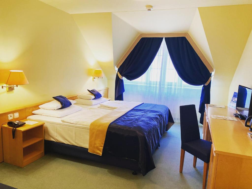 - une chambre avec un lit, un bureau et une fenêtre dans l'établissement Parkhotel na Baračke, à Trenčianske Teplice