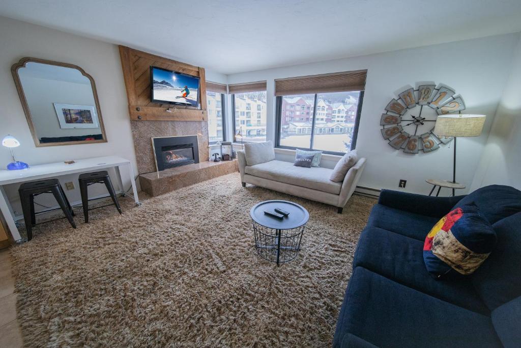 a living room with a blue couch and a fireplace at Edgewater 1436 in Keystone