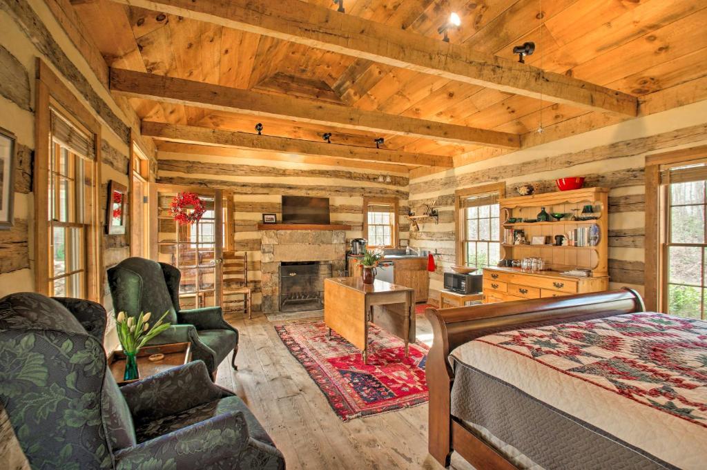 una baita di tronchi con soggiorno dotato di letto e camino di Lovely Wooded Cabin with Numerous Trails On-Site! a Earlysville