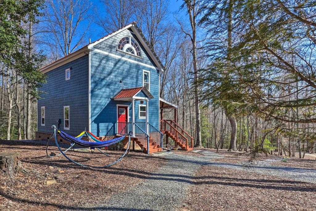 una casa azul con un patio de juegos delante de ella en Yadkin Valley Cabin Retreat with Deck, Fire Pit, 