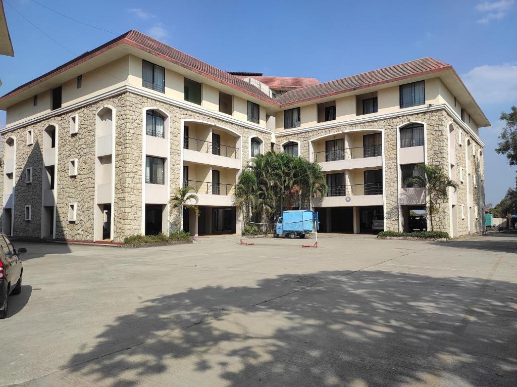 duży budynek z parkingiem przed nim w obiekcie 1BHK AC Service Apartment 115 w mieście Pune