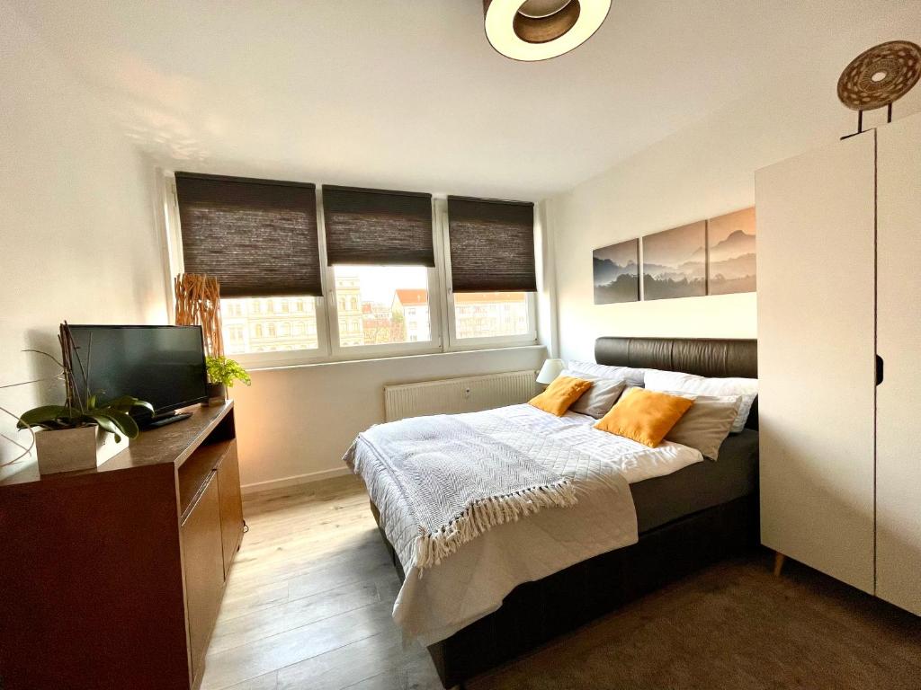 een slaapkamer met een bed en een tv. bij Gästeapartment Leipzig Mitte in Leipzig