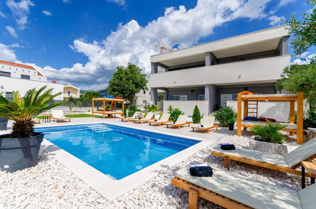 a swimming pool in the backyard of a house at Deluxe double room with sauna and pool in Kaštela