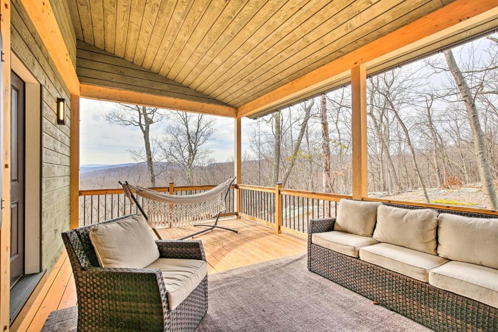 a screened in porch with two chairs and a hammock at The Glabin Garrison Gem with Deck and Fire Pit! in Garrison