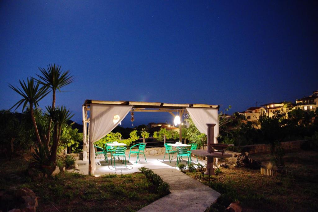 a gazebo with a table and chairs at night at ORFEAS HOUSE 2 in Patitiri