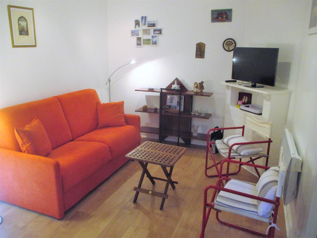 een woonkamer met een oranje bank en stoelen bij LES PAILLETTES in Le Touquet-Paris-Plage