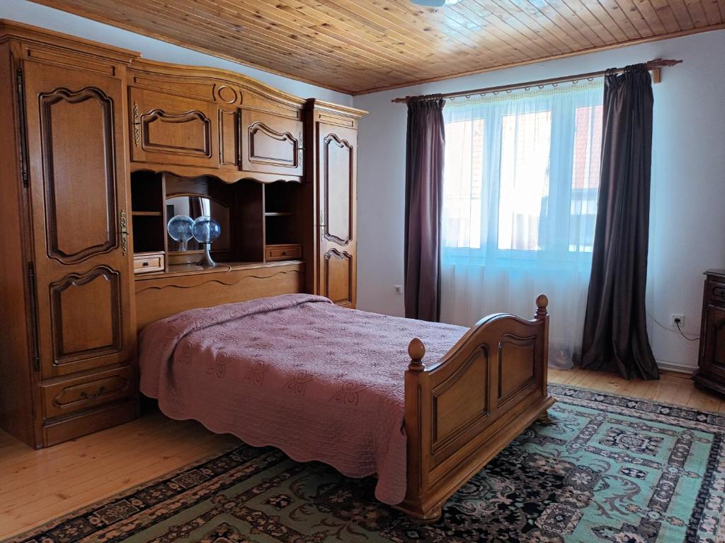 een slaapkamer met een groot bed en een groot raam bij La Remus in Moieciu de Jos