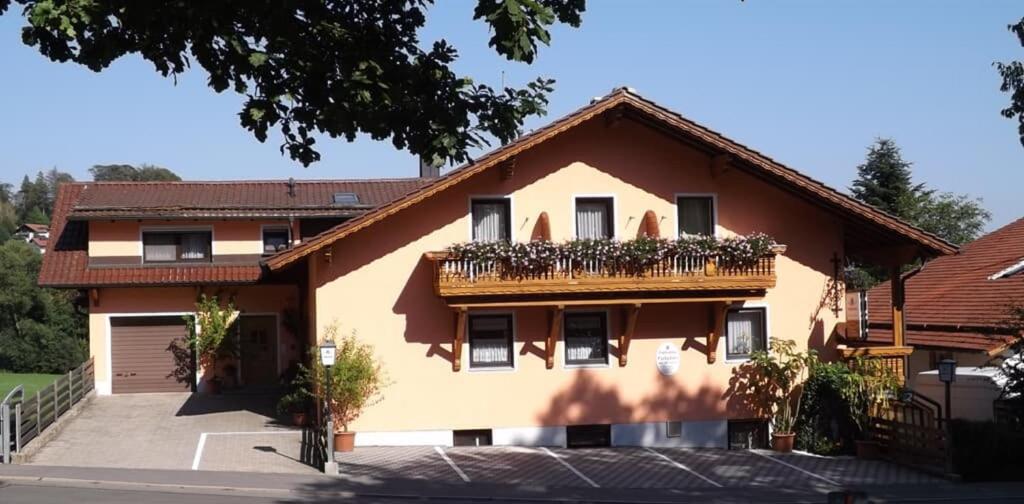 una casa con un balcón con plantas. en Pension Eichertstüberl, en Furth im Wald