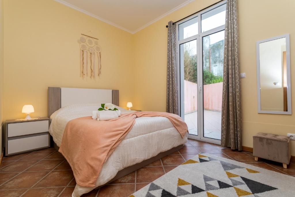 a bedroom with a bed and a large window at Furnas Cozy Inn in Furnas