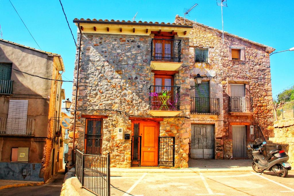 a stone building with a scooter parked in front of it at Artesola in Onda