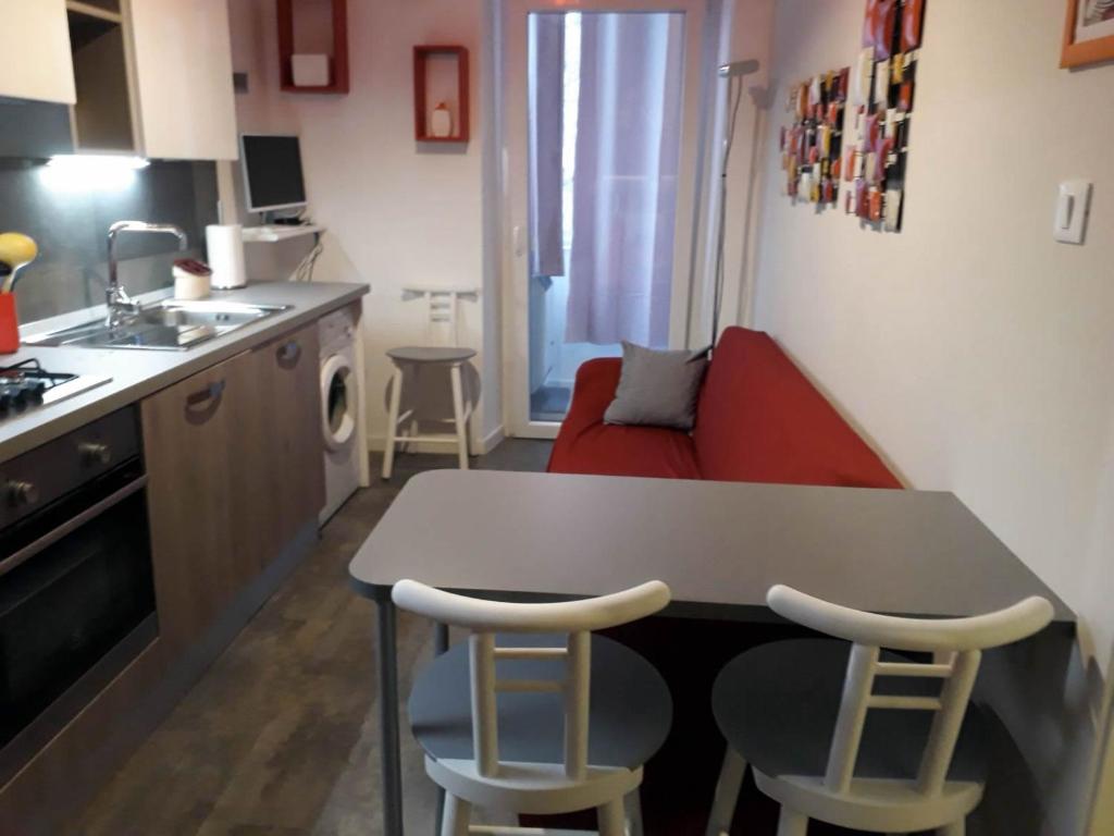 een kleine keuken met een tafel en twee krukken bij Casa Vacanze Belli2 in Trieste