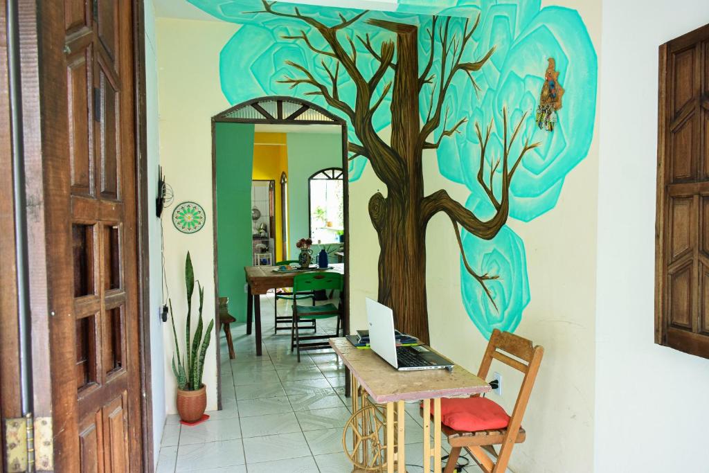 un couloir orné d'une fresque murale représentant les arbres dans l'établissement Casa da Mineira Hospedaria, à Lençóis