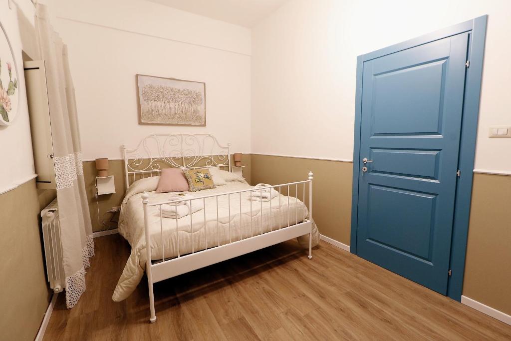 niewielka sypialnia z łóżkiem i niebieskimi drzwiami w obiekcie CentroCittà Comfort w Katanii