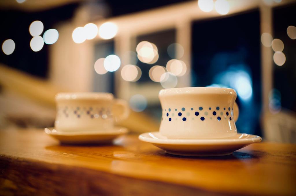 two cups and saucers sitting on a table at It's Mine Hostel in Taitung City
