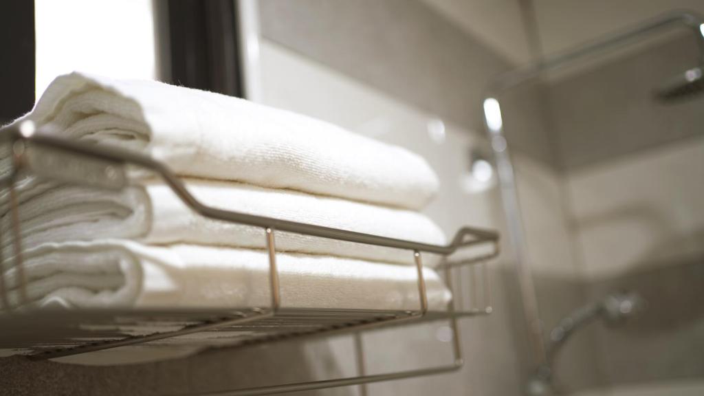 a towel rack with towels on it in a bathroom at It's Mine Hostel in Taitung City