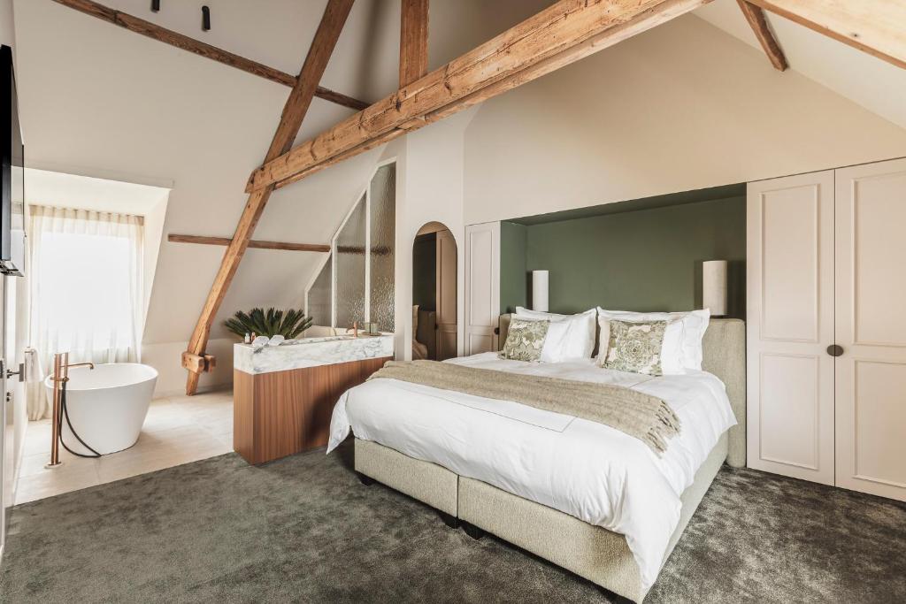 - une chambre avec un grand lit et une baignoire dans l'établissement Raphaëlles Boutique b&b, à Bruges