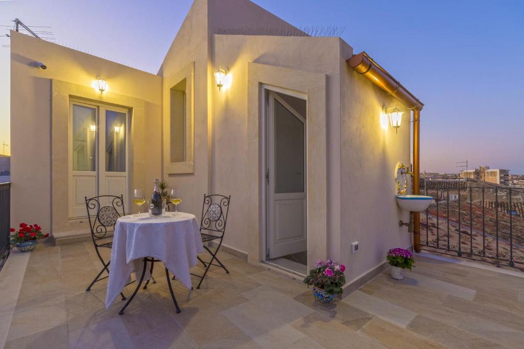 un tavolo e sedie su un balcone con vista di Corinzia Casa Vacanze a Siracusa