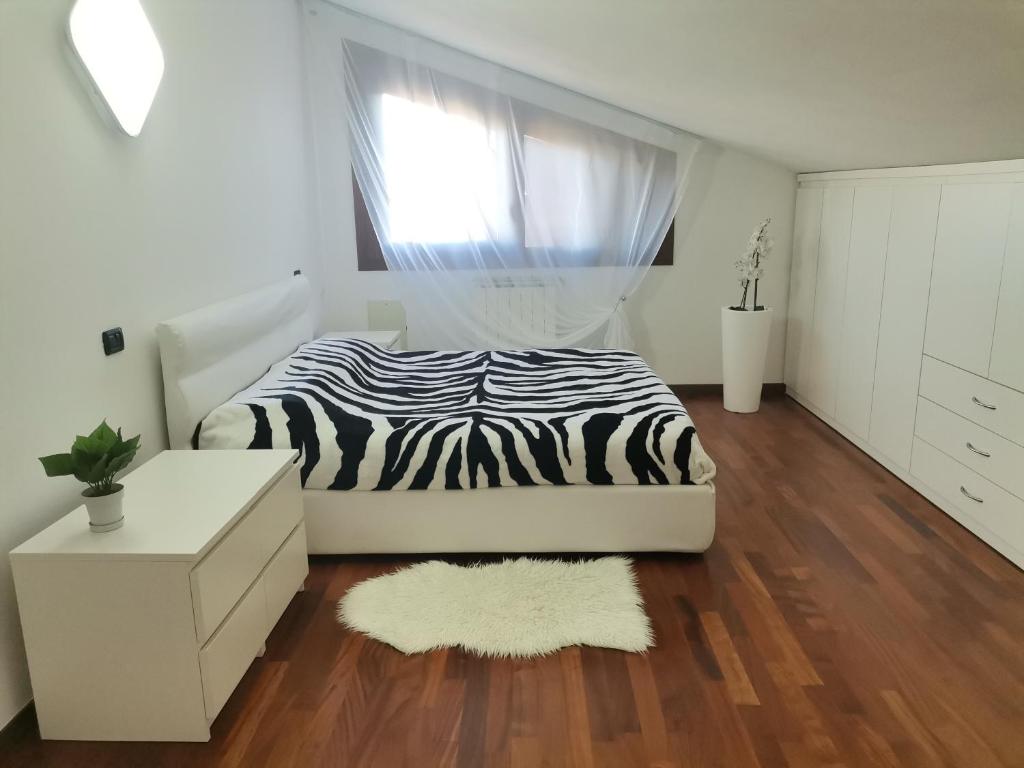 ein Schlafzimmer mit einem Zebra-Bett und einem Fenster in der Unterkunft Casa di Vika in Volta Barozzo