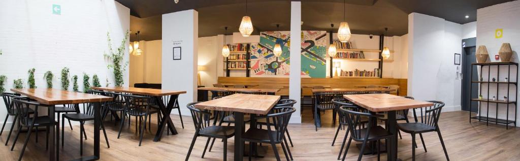 - un restaurant avec des tables et des chaises en bois dans une chambre dans l'établissement La Central Sevilla, à Séville