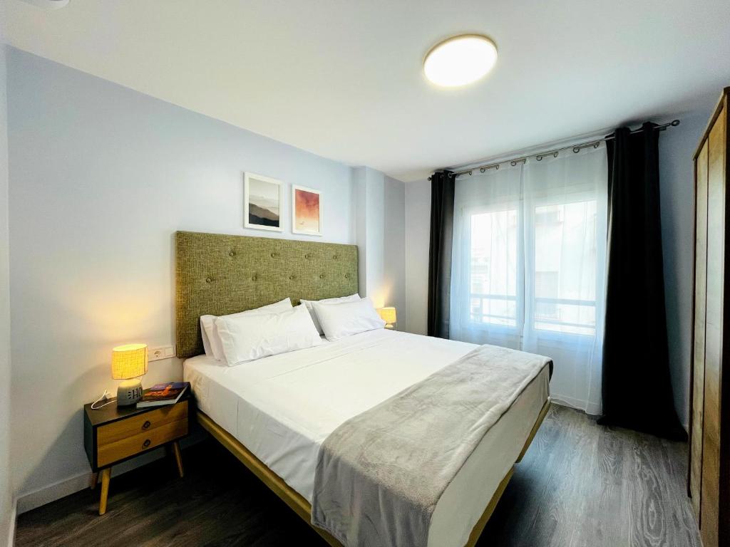 a bedroom with a large bed and a window at CASA SOHO Y ALEX in Estepona